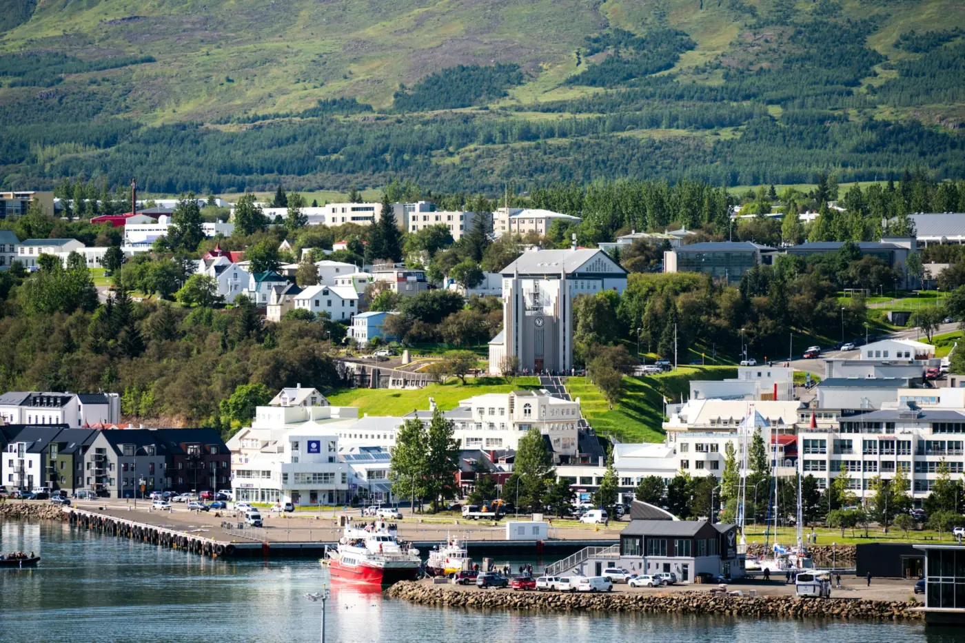 Akureyri town centre by the harbour, the church on the hill and green slopes behind